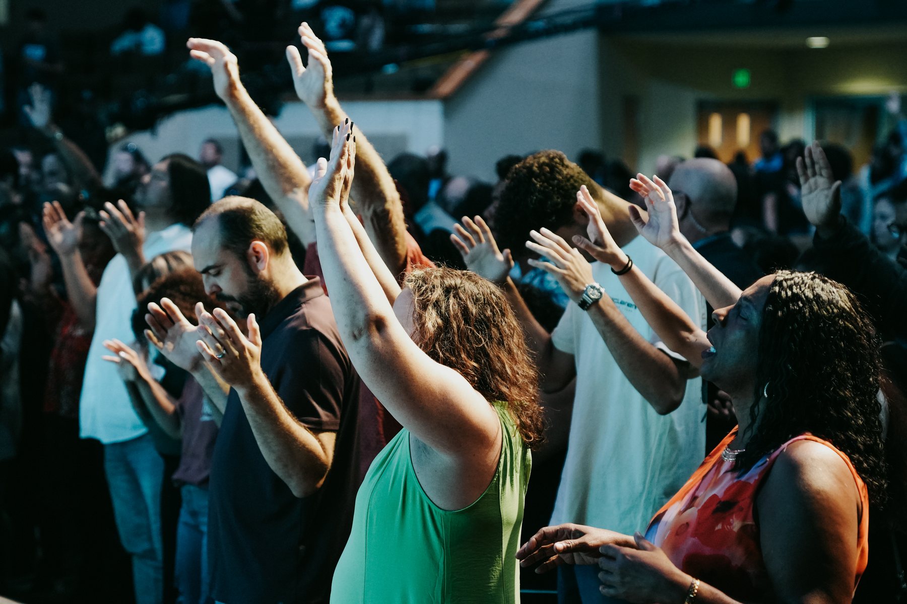 People lifting hands in prayer at an invitation event